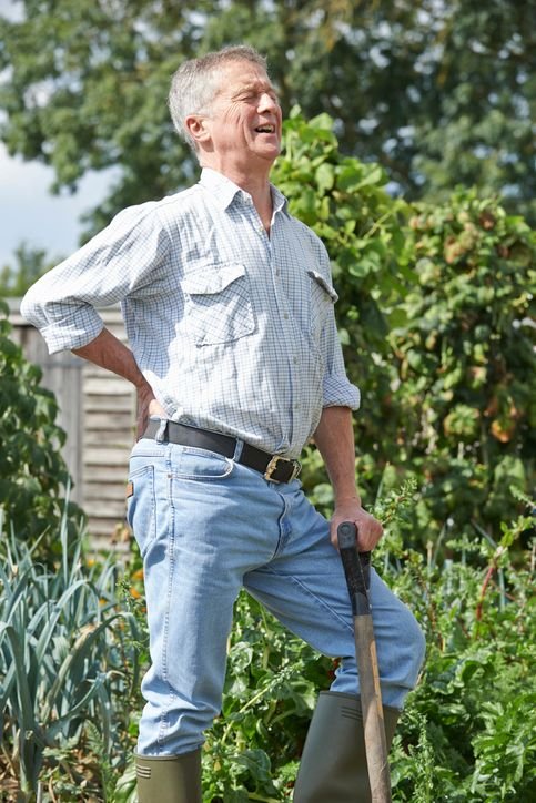 Man in the garden suffering from back pain. JOI Rehab